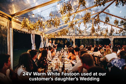 Outdoor wedding reception with white festoon lightings overhead
