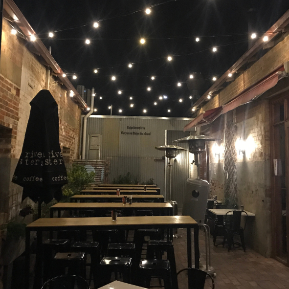 festoon lights hanging above outdoor restaurant sitting area
